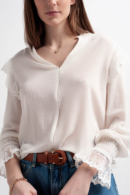 Blusa com volume nas mangas e rufos nos punhos em cor creme.