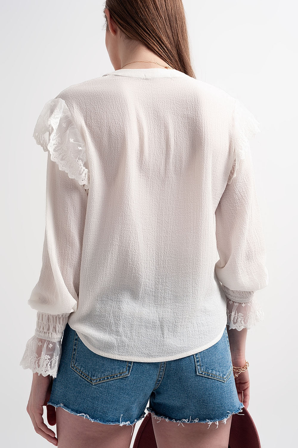 Blusa com volume nas mangas e rufos nos punhos em cor creme.