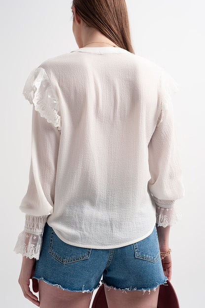 Blusa com volume nas mangas e rufos nos punhos em cor creme.