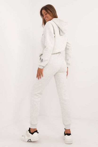 Woman wearing a light gray women's tracksuit set with hoodie and jogger pants from Factory Price