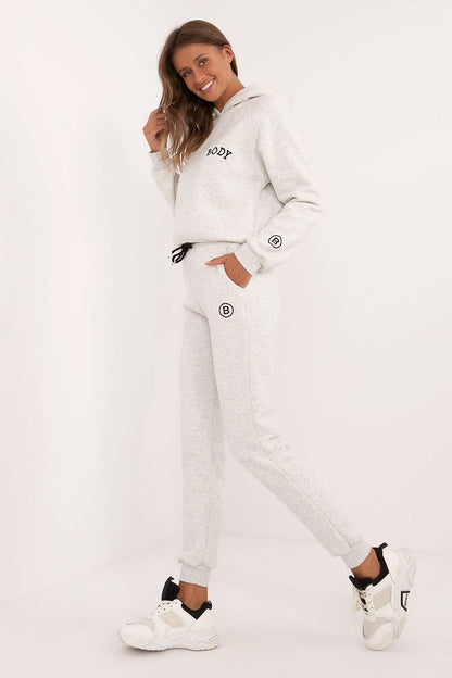 Factory Price women's tracksuit set in light gray with hoodie and jogger pants worn with white sneakers