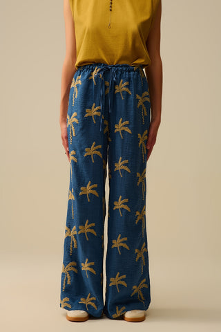 Calça de perna larga azul com bordado de palmeira bege