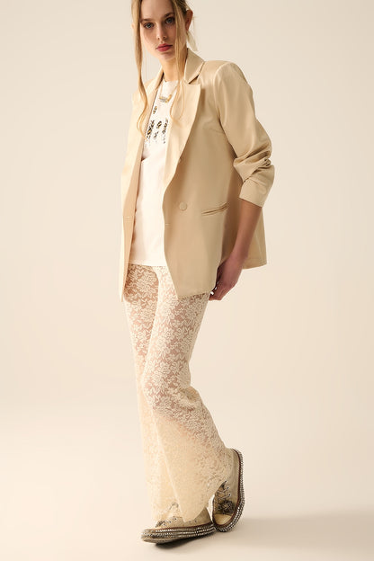 Calça flare de creme em renda floral