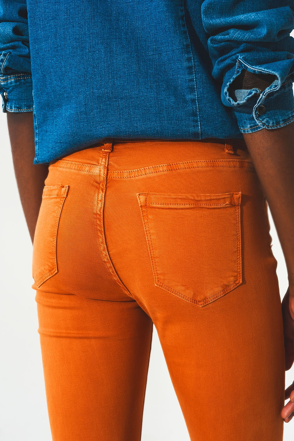 Calça jeans flare com bainha desfiada em laranja