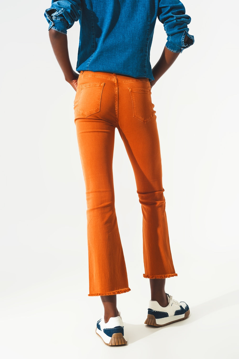 Calça jeans flare com bainha desfiada em laranja