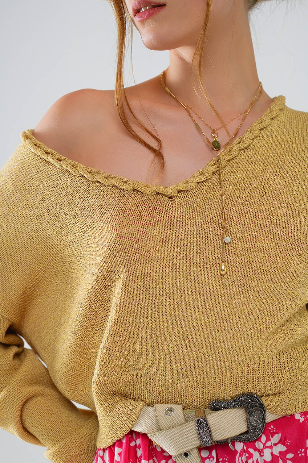 Camisola leve com decotes em V largo e detalhes entrançados em dourado