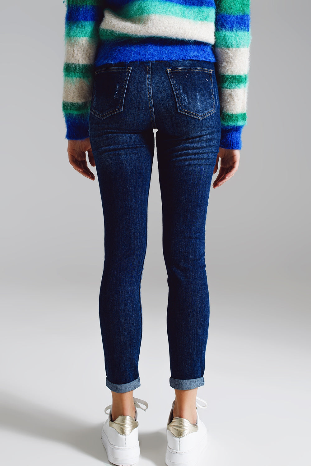 Jeans super skinny com botões frontais visíveis em azul médio