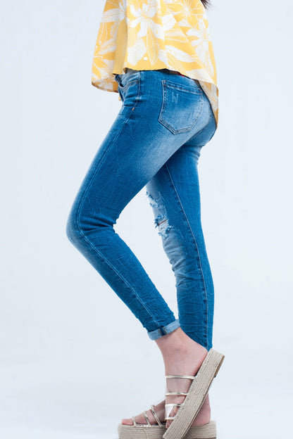 Jeans justo com lavagem média e rasgos