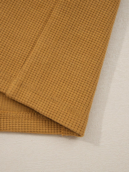 Close-up of an Oversized Textured Split Neck High Low Sweatshirt in warm brown with soft fabric detailing