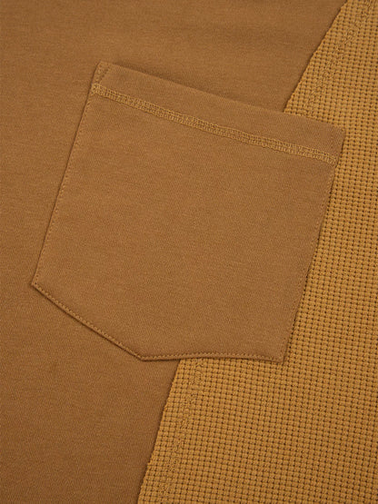 Close-up of Oversized Textured Split Neck High Low Sweatshirt featuring a pocket detail in a warm brown tone
