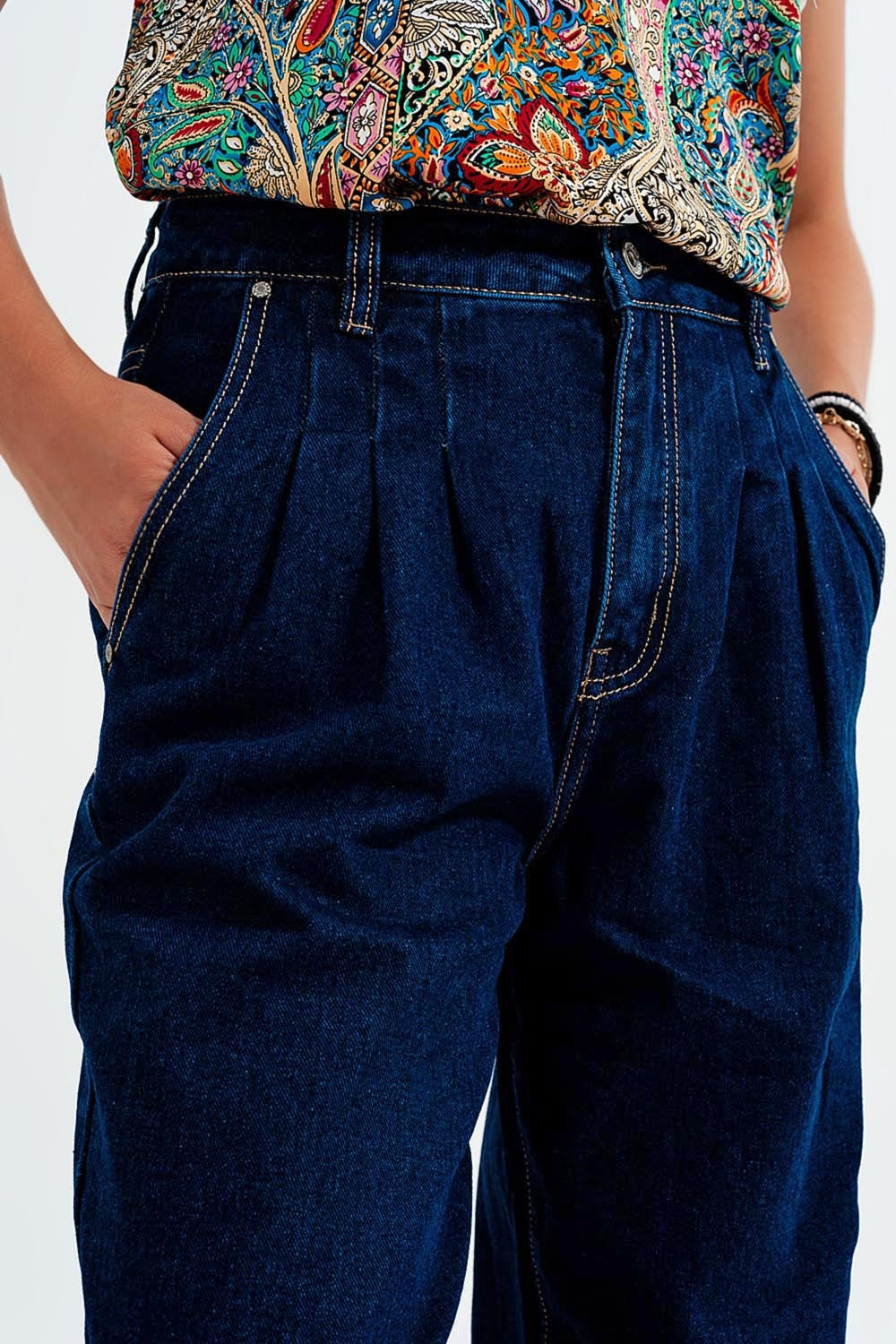 Jeans com pregas frontais e corte relaxado em azul escuro