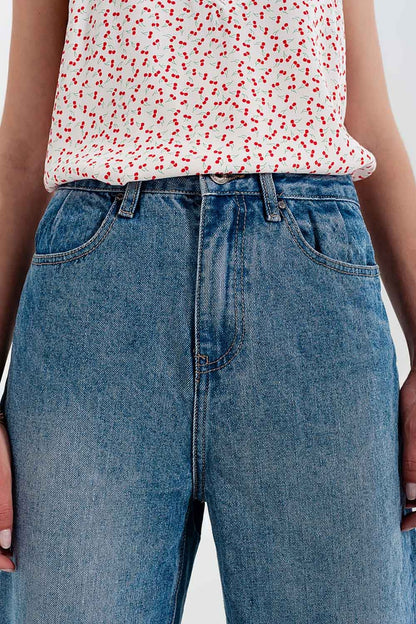 Jeans com rasgos laterais e corte relaxado em azul médio