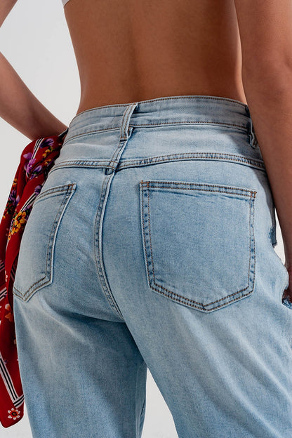 Jeans rasgado com perna reta e detalhe de botão em azul claro