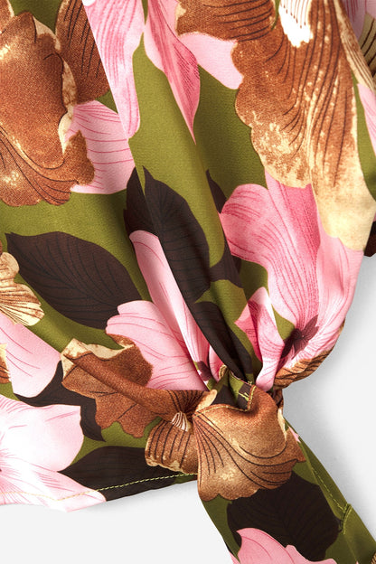 Top com nó floral e fundo verde em tecido acetinado