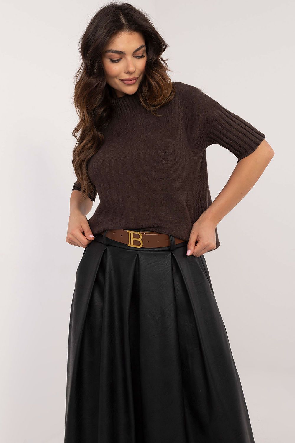 BFG brown short sleeve turtle neck sweater worn with black pleated skirt and brown belt